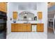 Bright kitchen with oak cabinets, stainless steel refrigerator, and white tile floors at 905 White Thunder St, Henderson, NV 89002