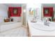 Main bathroom featuring double sinks, soaking tub and glass shower with red accent wall at 905 White Thunder St, Henderson, NV 89002