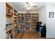 Cozy office space featuring built-in bookshelves, wood flooring, and a ceiling fan at 905 White Thunder St, Henderson, NV 89002