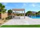 Beautiful backyard area with a pool and pergola surrounded by tropical landscaping at 9475 W Rosada Way, Las Vegas, NV 89149