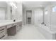 Bright bathroom features a double vanity, soaking tub, and tiled floor at 9475 W Rosada Way, Las Vegas, NV 89149