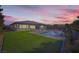 A nighttime shot of a home with a pristine lawn and a beautiful pool at 9475 W Rosada Way, Las Vegas, NV 89149