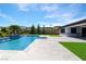 A stunning backyard pool with a water feature, spacious patio, and lush landscaping at 9475 W Rosada Way, Las Vegas, NV 89149