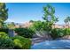 Lush backyard landscape featuring mature trees, greenery, and a view of the surrounding neighborhood at 9524 Quail Ridge Dr, Las Vegas, NV 89134