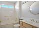 Bathroom showcasing a combination tub and shower, with a vanity and a round mirror at 9524 Quail Ridge Dr, Las Vegas, NV 89134