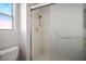 Bathroom with white tile and gold fixtures showcasing a sleek shower with a sliding door at 9524 Quail Ridge Dr, Las Vegas, NV 89134