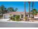 Inviting single-story home featuring a tile roof, attached garage, and tidy landscaping with palm trees at 9524 Quail Ridge Dr, Las Vegas, NV 89134