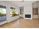 Cozy living room featuring hardwood floors, a fireplace, built-in shelving, and large windows at 9524 Quail Ridge Dr, Las Vegas, NV 89134