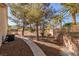 Serene outdoor space with gravel path, mature trees and privacy wall, offering a tranquil setting at 9524 Quail Ridge Dr, Las Vegas, NV 89134