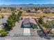 An aerial view showcases this single-story house's roof and desert surroundings at 100 Eton St, Pahrump, NV 89048