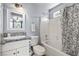 Well-lit bathroom with a shower-tub combination, patterned shower curtain and granite vanity at 100 Eton St, Pahrump, NV 89048