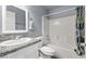 Well-maintained bathroom featuring a granite countertop, white cabinetry, and tiled shower with curtain at 100 Eton St, Pahrump, NV 89048