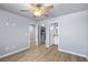 Bedroom with open closet and bathroom door featuring a ceiling fan and neutral color scheme at 100 Eton St, Pahrump, NV 89048