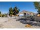 A single-story house featuring desert landscaping and a gate surrounding the property at 100 Eton St, Pahrump, NV 89048