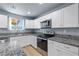 Updated kitchen with white cabinetry, granite countertops, and stainless steel appliances at 100 Eton St, Pahrump, NV 89048