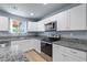 Updated kitchen with white cabinetry, granite countertops, and stainless steel appliances at 100 Eton St, Pahrump, NV 89048