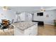 Open-concept living area with granite countertop island, wood-style floors, and neutral decor at 100 Eton St, Pahrump, NV 89048