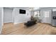 Bright living room featuring wood flooring, a modern futon, and neutral wall colors at 100 Eton St, Pahrump, NV 89048