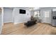 Bright living room featuring wood flooring, a modern futon, and neutral wall colors at 100 Eton St, Pahrump, NV 89048