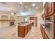Well-appointed kitchen with stainless steel appliances, wood cabinets, and a view of the cozy living room fireplace at 1044 Spanish Needle St, Henderson, NV 89002