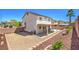 Wide angle view of the large backyard with covered patio, drought tolerant plants, and retaining wall at 1073 Nordyke Ave, Henderson, NV 89015