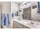 Bright bathroom boasts double sinks and luxurious glass shower with marble tile at 1073 Nordyke Ave, Henderson, NV 89015