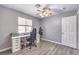 Cozy bedroom with ceiling fan, grey walls, and desk by sunlit window at 1073 Nordyke Ave, Henderson, NV 89015