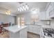 Bright kitchen with white cabinets, island with quartz countertop, dining table, and stainless steel appliances at 1073 Nordyke Ave, Henderson, NV 89015