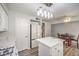 Bright kitchen features white cabinets, island with quartz countertop, dining table, and stainless steel appliances at 1073 Nordyke Ave, Henderson, NV 89015