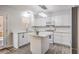 Bright kitchen features white cabinets, island with quartz countertop, and stainless steel appliances at 1073 Nordyke Ave, Henderson, NV 89015