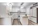 Modern kitchen featuring white cabinetry, stainless steel appliances, an island, and wood-look flooring at 1073 Nordyke Ave, Henderson, NV 89015