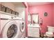 Vibrant laundry room featuring updated washer and dryer, storage shelves, sink, and mirror at 1073 Nordyke Ave, Henderson, NV 89015