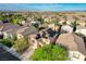 Aerial view showcasing a home with solar panels, lush landscaping, and a neighborhood with mountain views at 10988 Salernes St, Las Vegas, NV 89141