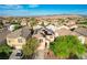 Aerial view of a home with solar panels, a well-maintained yard, and a community of homes and mountains in the background at 10988 Salernes St, Las Vegas, NV 89141