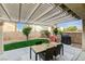 Cozy backyard with a patio, shaded pergola, dining set, and lush lawn, perfect for outdoor entertaining at 10988 Salernes St, Las Vegas, NV 89141