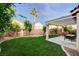 Landscaped backyard featuring a covered patio, outdoor dining space, lush lawn, and mature trees, creating a peaceful oasis at 10988 Salernes St, Las Vegas, NV 89141
