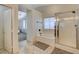 Bathroom featuring a glass-enclosed shower, soaking tub, and window, creating a bright and relaxing retreat at 10988 Salernes St, Las Vegas, NV 89141