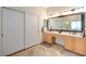Bright bathroom featuring a double vanity, a large framed mirror, and neutral-toned flooring, providing a serene atmosphere at 10988 Salernes St, Las Vegas, NV 89141
