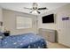 Comfortable bedroom featuring a ceiling fan, window with blinds, television, and dresser at 10988 Salernes St, Las Vegas, NV 89141