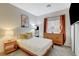 Well-lit bedroom with a wooden frame bed, stylish decor, and plush carpet at 10988 Salernes St, Las Vegas, NV 89141