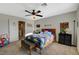 Comfortable bedroom with ceiling fan, bed with dinosaur-themed linens, and ample space at 10988 Salernes St, Las Vegas, NV 89141