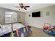 Nicely appointed bedroom with ceiling fan, bed with dinosaur-themed linens, and large window at 10988 Salernes St, Las Vegas, NV 89141