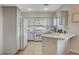 Well-lit kitchen featuring white cabinets, modern appliances, and a convenient breakfast bar at 10988 Salernes St, Las Vegas, NV 89141