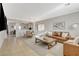 Spacious living room featuring tile floors, a brown leather sofa set, and an open-concept layout at 10988 Salernes St, Las Vegas, NV 89141
