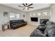 Bright living room features tile floors, a ceiling fan, and a cozy fireplace with mantel and decorative accents at 10988 Salernes St, Las Vegas, NV 89141