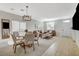 Open-concept living room with a dining area, featuring tile floors and modern lighting fixtures at 10988 Salernes St, Las Vegas, NV 89141