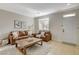Inviting living room with tile floors, a comfortable sofa set, and a large window for natural light at 10988 Salernes St, Las Vegas, NV 89141