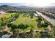 Expansive community park featuring lush green space and walking trails among tree-lined neighborhoods under a bright, sunny sky at 10988 Salernes St, Las Vegas, NV 89141