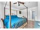 Well-lit bedroom featuring wood-look floors, canopy bed and blue bedding at 110 Huckleberry Ln, Henderson, NV 89074