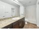 Bright bathroom with a granite countertop, white cabinets, and wood-look flooring at 12112 Polar White Ct # 3, Las Vegas, NV 89183